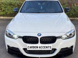 A white BMW car is parked on a paved surface, with 